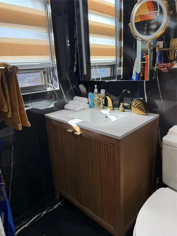 a bathroom with a granite countertop sink and a mirror
