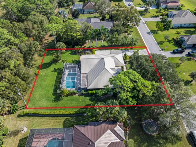 an aerial view of a house with a yard and lake view