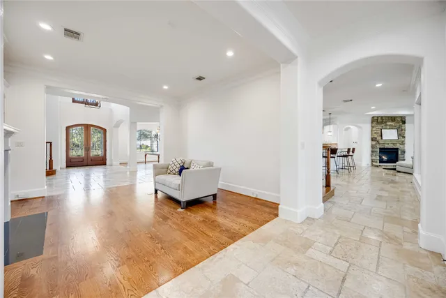 a living room with furniture and a dining table with wooden floor
