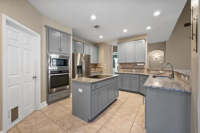 a kitchen with kitchen island granite countertop stainless steel appliances and a sink