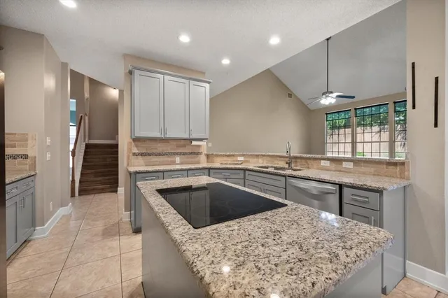 a kitchen with a sink a counter top space stainless steel appliances and a window