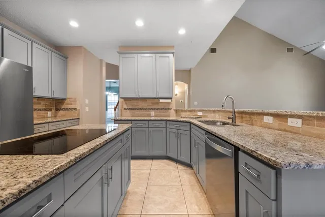 a kitchen with granite countertop a sink a counter space and cabinets