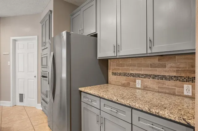 a kitchen with granite countertop cabinets and refrigerator