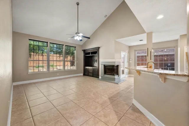 a view of an empty room with a fireplace and a window