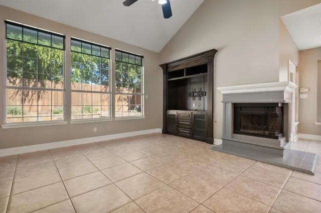 a view of an empty room with a fireplace and a window