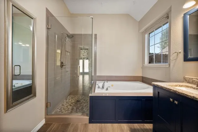 a bathroom with a tub a sink and mirrors