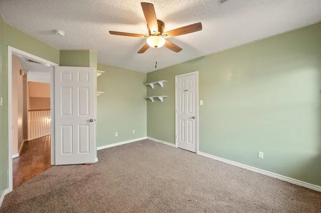 an empty room with closet and a chandelier fan