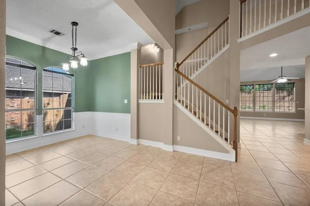 a view of a hallway with windows and chandelier