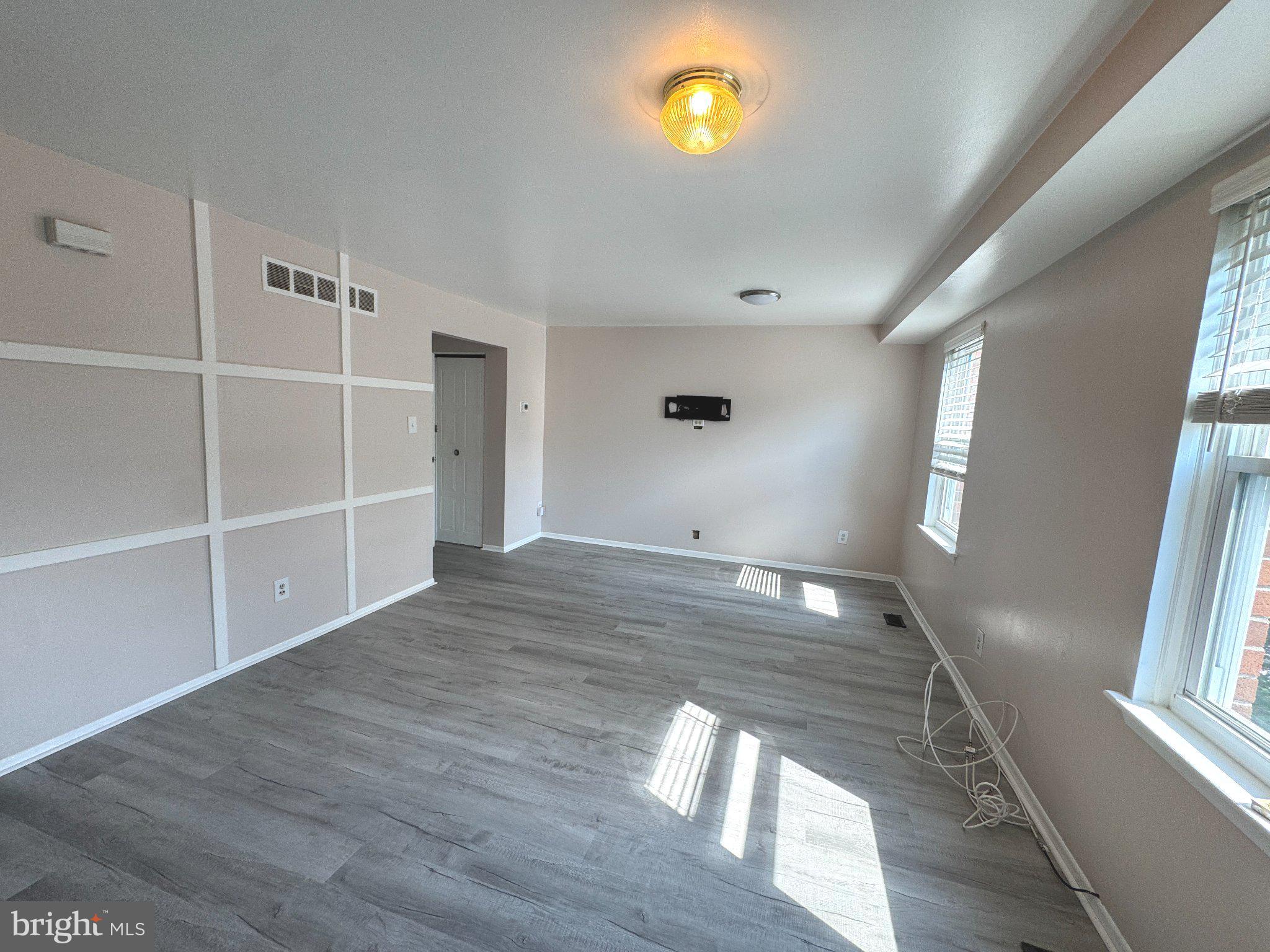12044 Abby Road, Unit 1 Philadelphia, PA 19154 - Photo 4 of 10 a view of an empty room with wooden floor and a window