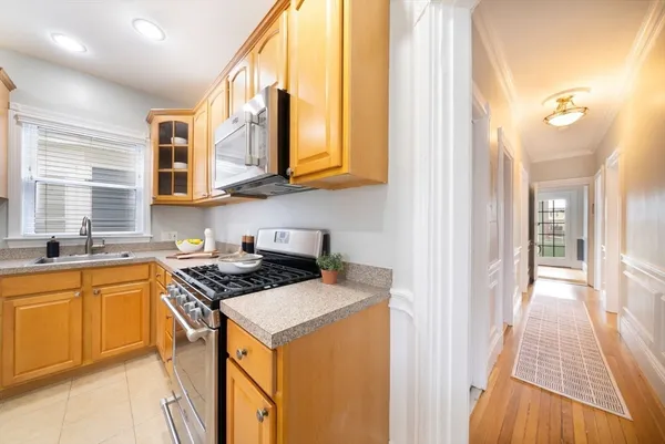 a kitchen with stainless steel appliances granite countertop a stove a sink and a microwave