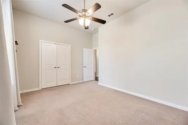 an empty room with chandelier fan
