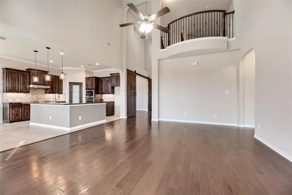 a view of a kitchen with wooden floor and a ceiling fan
