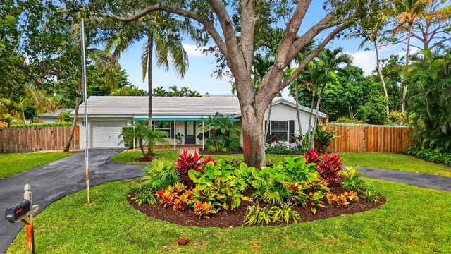 a front view of a house with a yard and fountain in middle