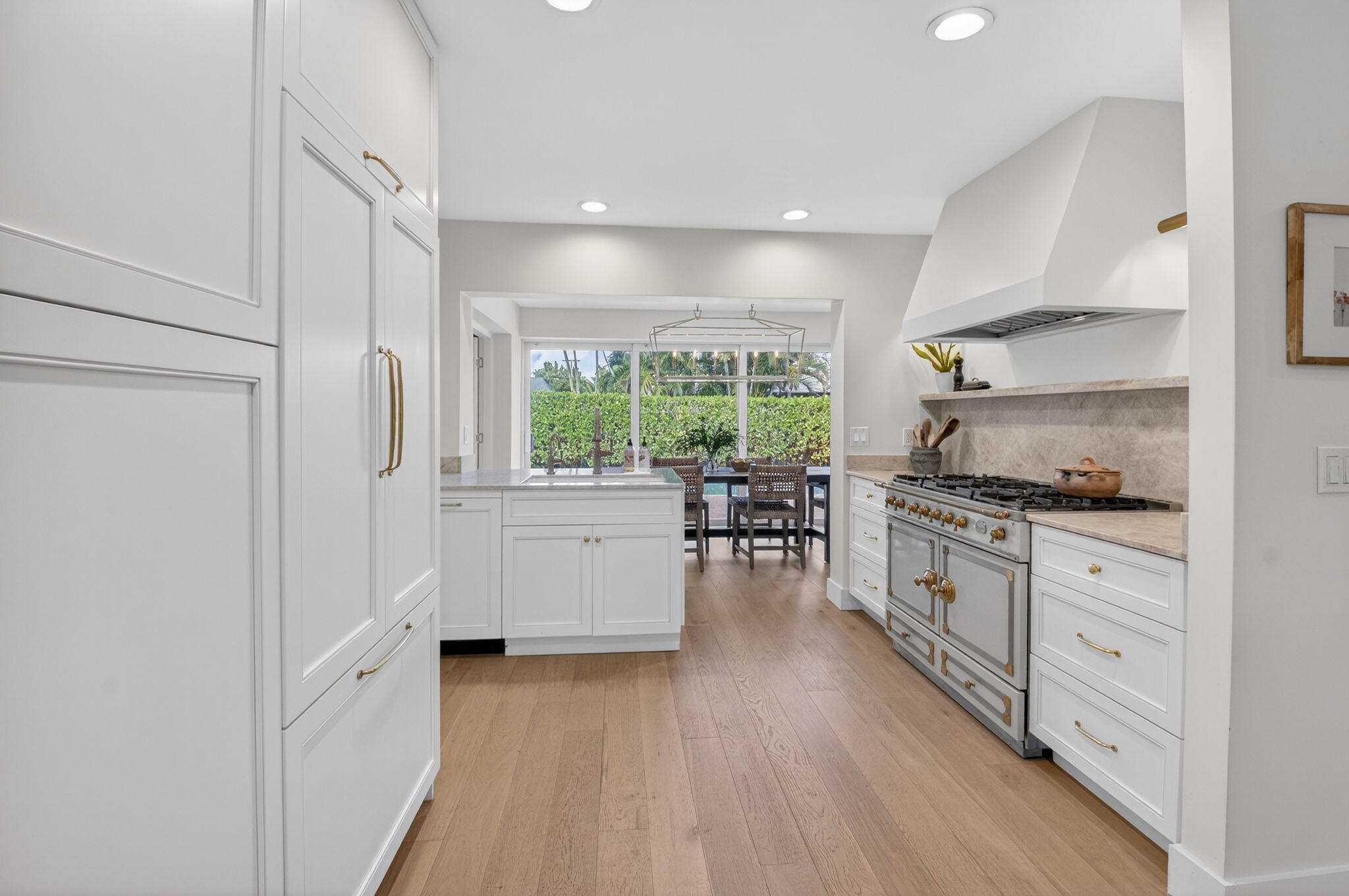 525 Sunset Road Boynton Beach, FL 33435 - Photo 12 of 62 a kitchen with granite countertop a stove top oven a sink a dining table and chairs with wooden floor