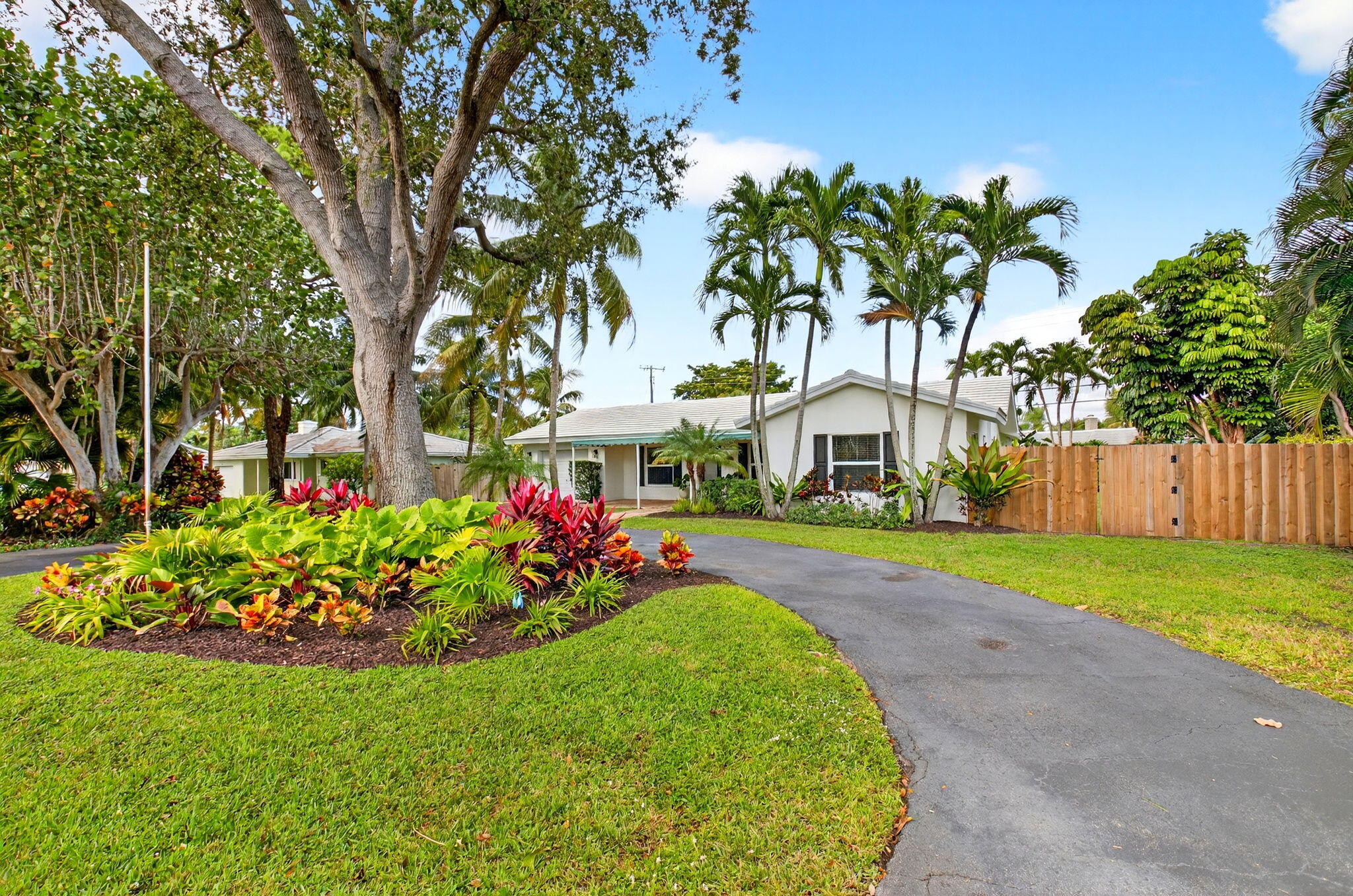 525 Sunset Road Boynton Beach, FL 33435 - Photo 4 of 62 a front view of a house with a big yard and potted plants