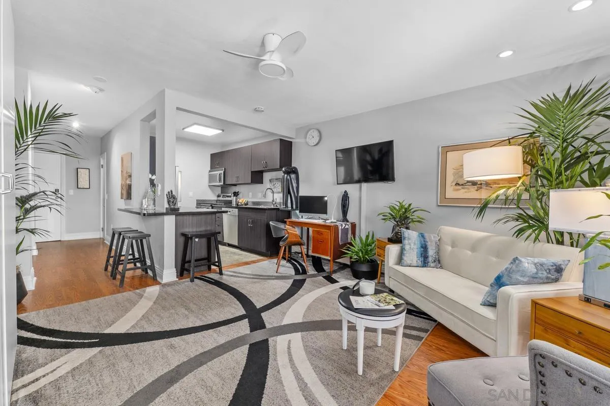 3980 8th Avenue, Unit 308 San Diego, CA 92103 - Photo 1 of 33 a living room with furniture and a dining table with potted plants