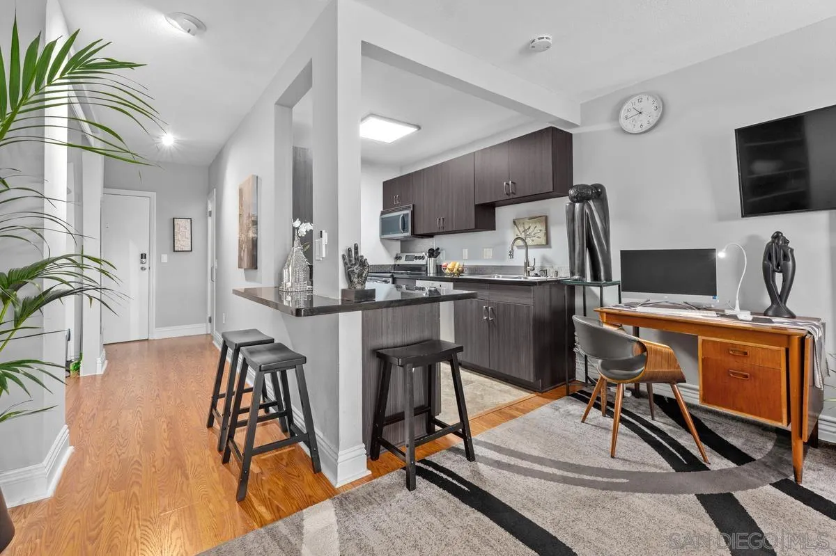 3980 8th Avenue, Unit 308 San Diego, CA 92103 - Photo 14 of 33 a kitchen with stainless steel appliances kitchen island granite countertop a table chairs refrigerator and sink