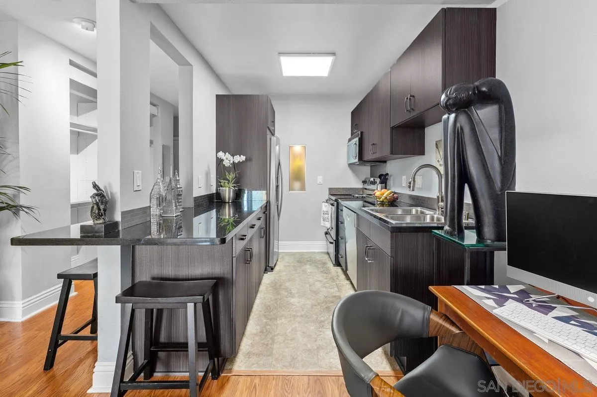 3980 8th Avenue, Unit 308 San Diego, CA 92103 - Photo 15 of 33 a kitchen with stainless steel appliances granite countertop a stove a refrigerator a sink dishwasher and furniture