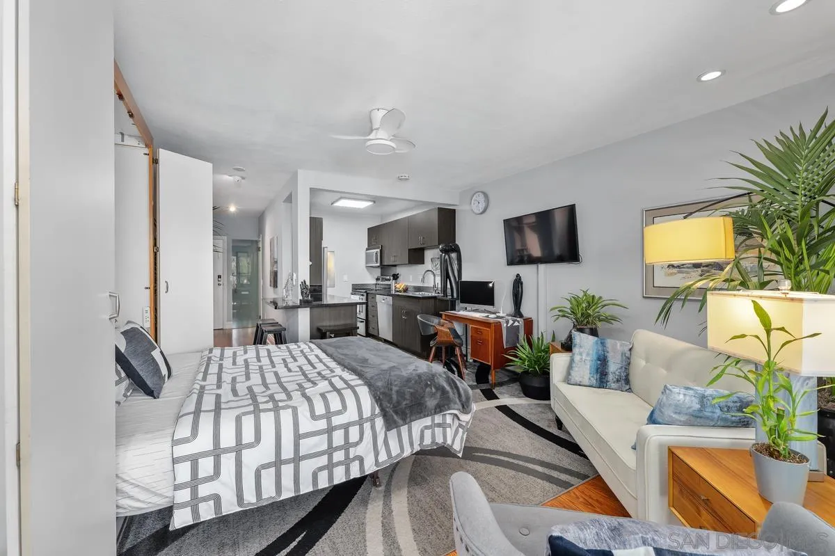 3980 8th Avenue, Unit 308 San Diego, CA 92103 - Photo 2 of 33 a bedroom with a bed a couch and a flat tv screen on dresser