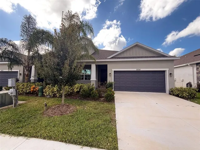 a front view of a house with a garden and yard