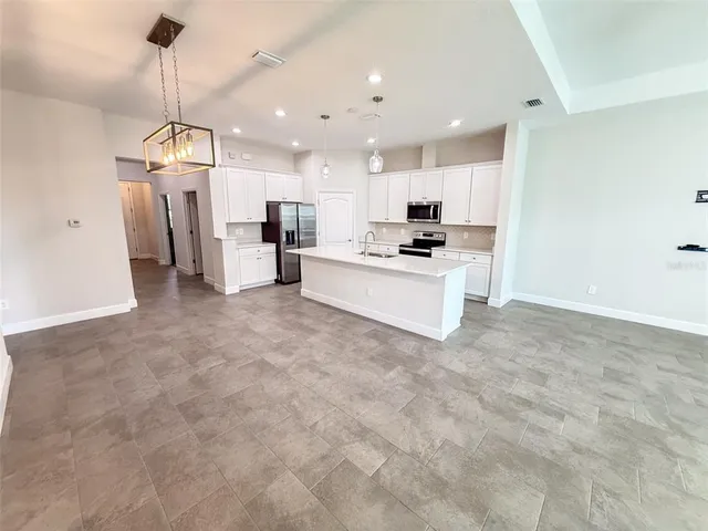 a view of a kitchen with refrigerator microwave and stove top oven