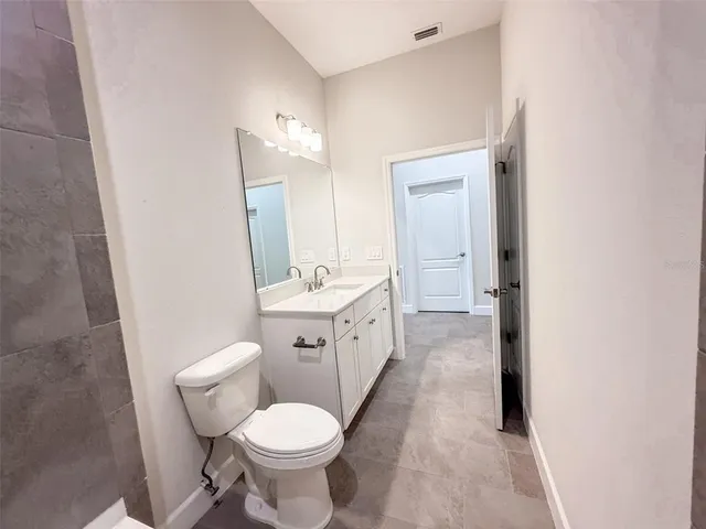 a bathroom with a double vanity sink toilet and mirror