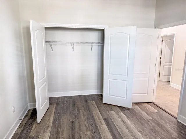 an empty room with wooden floor and closet