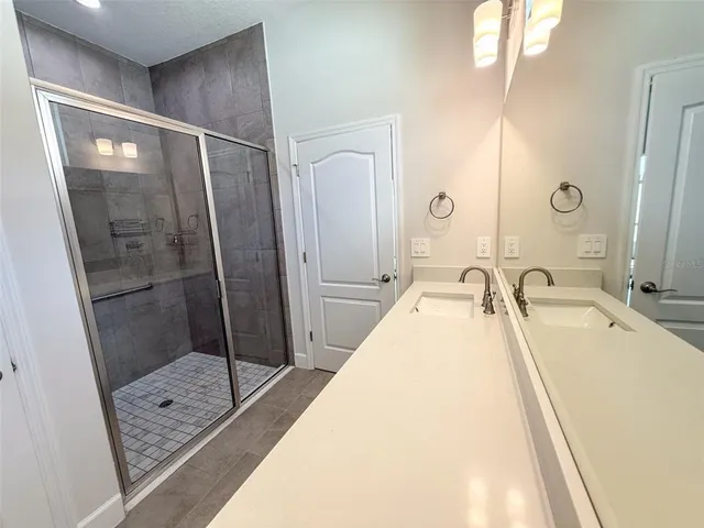 a bathroom with a tub sink mirror and shower