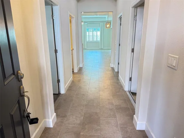 a view of a hallway with wooden floor and stairs