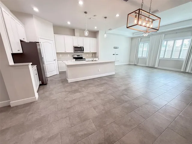 a large kitchen with a large counter top appliances and cabinets