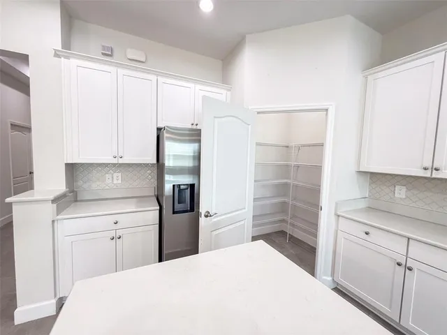 a kitchen with a refrigerator sink and cabinets