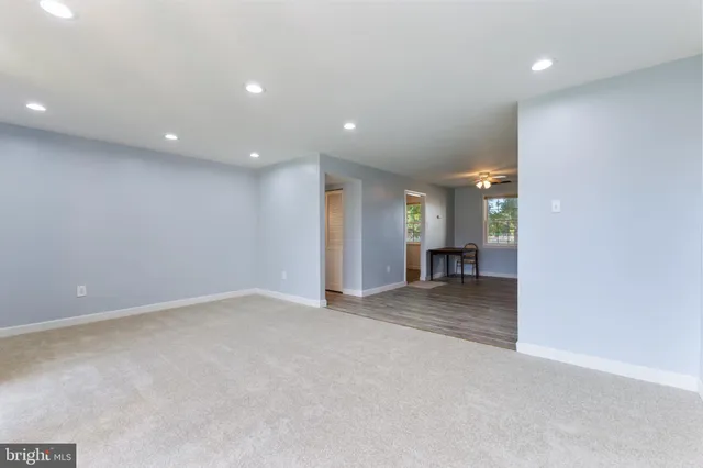 a view of a livingroom with a staircase and kitchen space