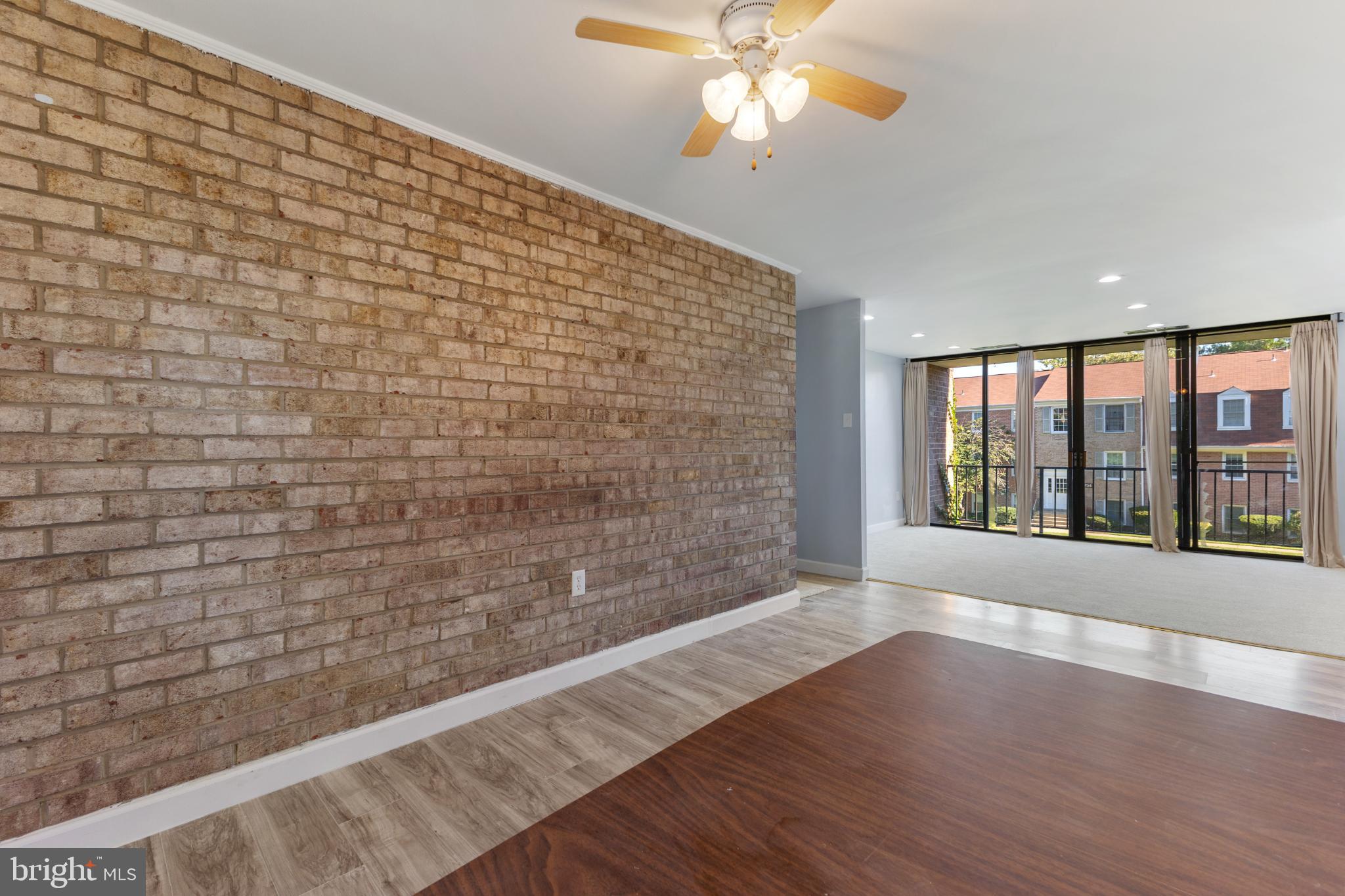 776 Quince Orchard Boulevard, Unit 102 Gaithersburg, MD 20878 - Photo 4 of 14 a view of an empty room with a window and wooden floor