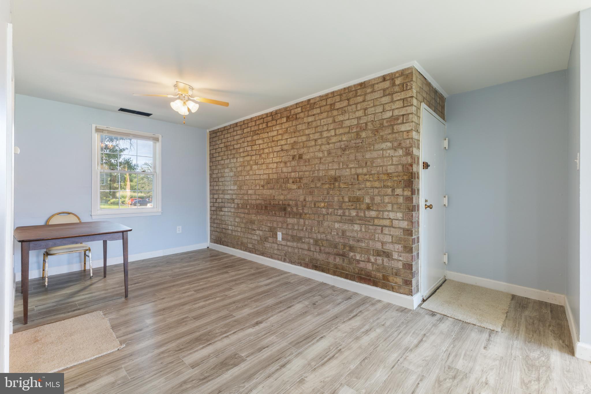 776 Quince Orchard Boulevard, Unit 102 Gaithersburg, MD 20878 - Photo 5 of 14 a view of an empty room with a window and wooden floor