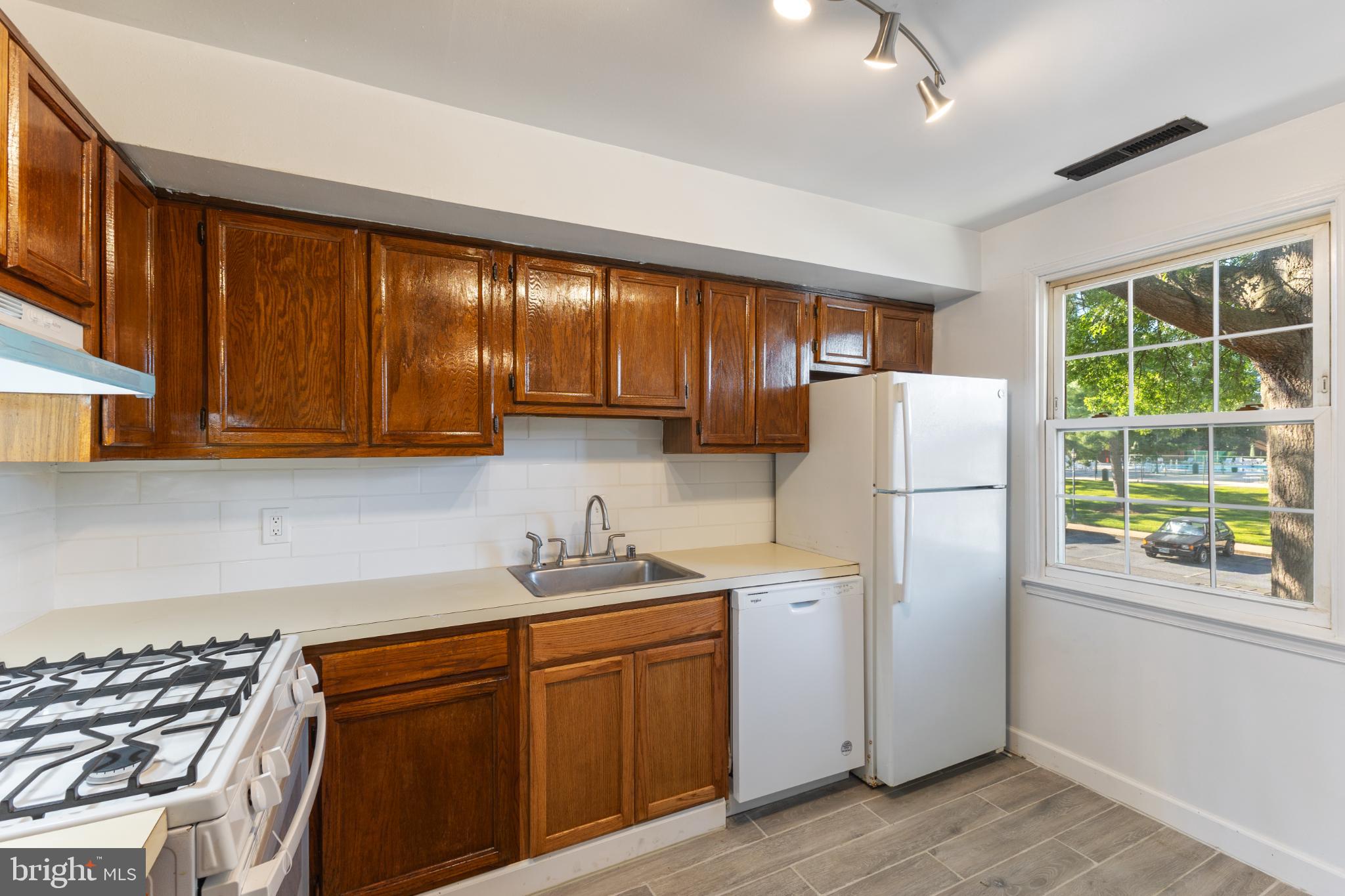 776 Quince Orchard Boulevard, Unit 102 Gaithersburg, MD 20878 - Photo 9 of 14 a kitchen with stainless steel appliances granite countertop a refrigerator sink and cabinets