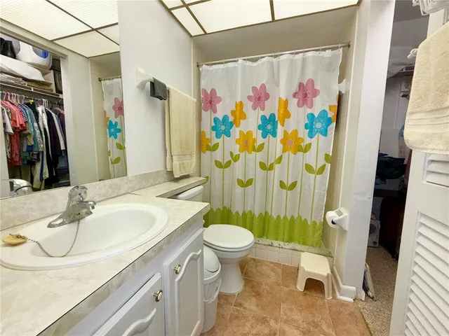a bathroom with a sink toilet and shower curtain