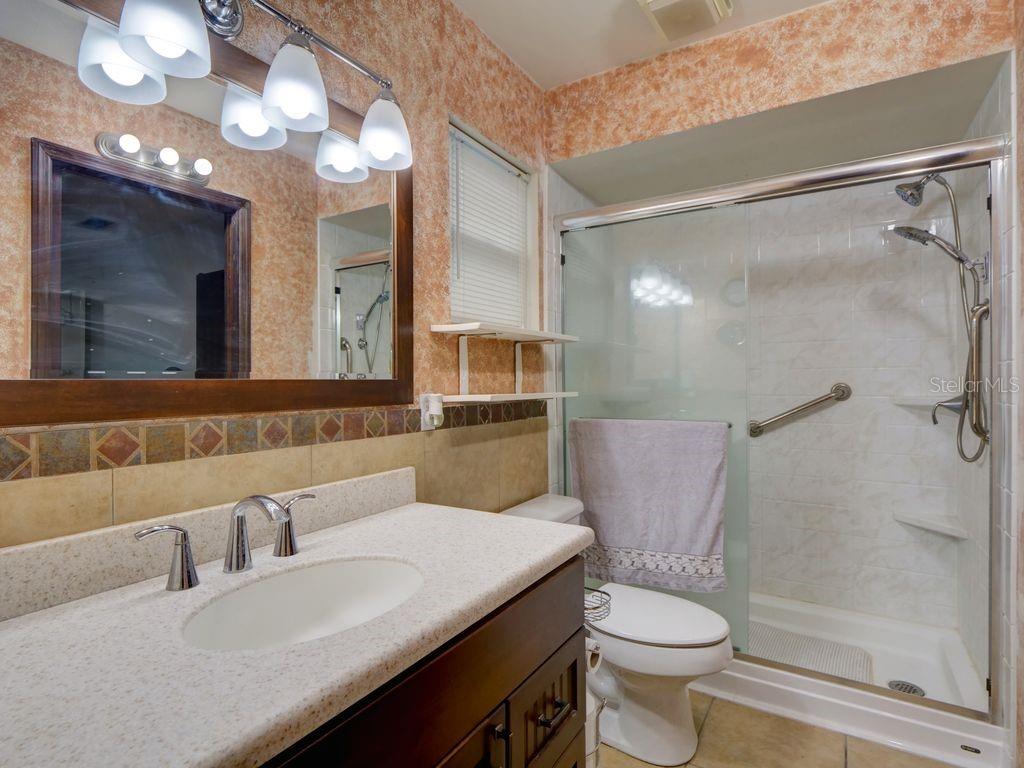 698 Colchester Avenue Deltona, FL 32738 - Photo 14 of 30 a bathroom with a sink a toilet a mirror and shower