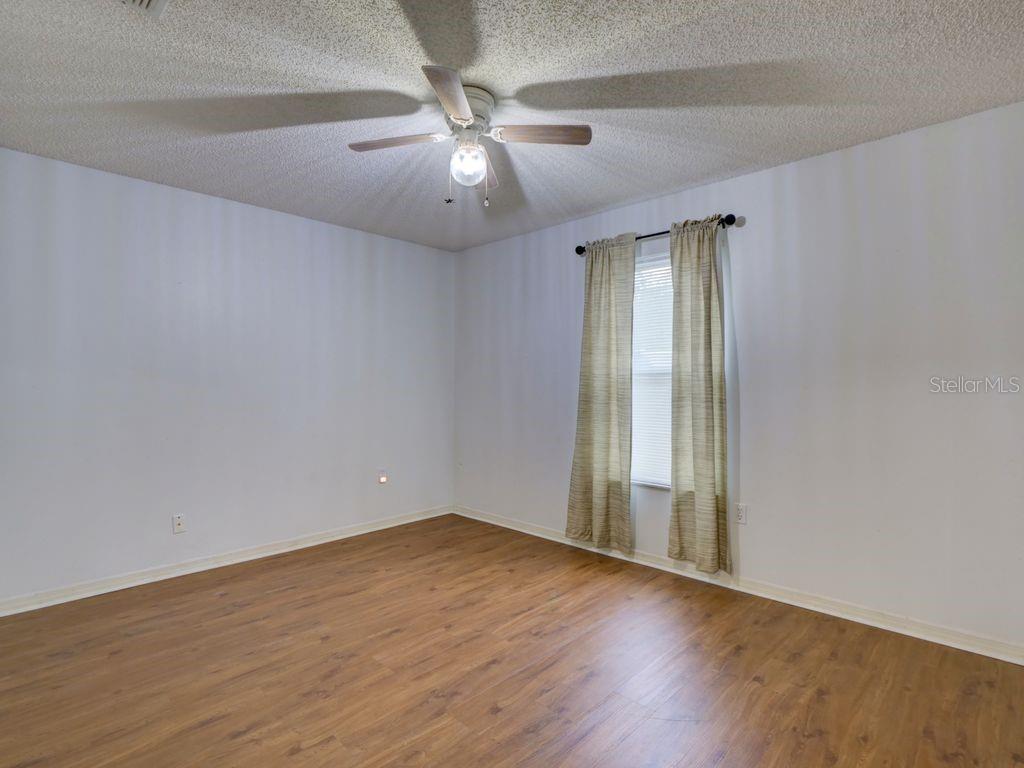 698 Colchester Avenue Deltona, FL 32738 - Photo 15 of 30 an empty room with wooden floor and windows