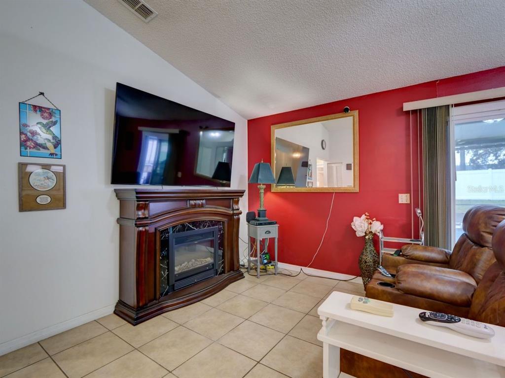 698 Colchester Avenue Deltona, FL 32738 - Photo 5 of 30 a living room with furniture and a fireplace