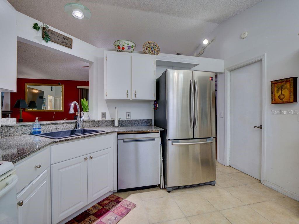 698 Colchester Avenue Deltona, FL 32738 - Photo 9 of 30 a kitchen with stainless steel appliances granite countertop a refrigerator and a sink