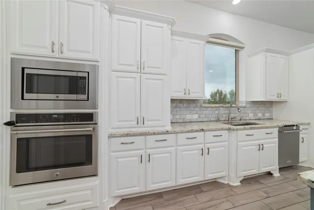 a kitchen with white cabinets stainless steel appliances and sink