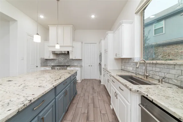 a kitchen with granite countertop kitchen island stainless steel appliances sink stove and cabinets
