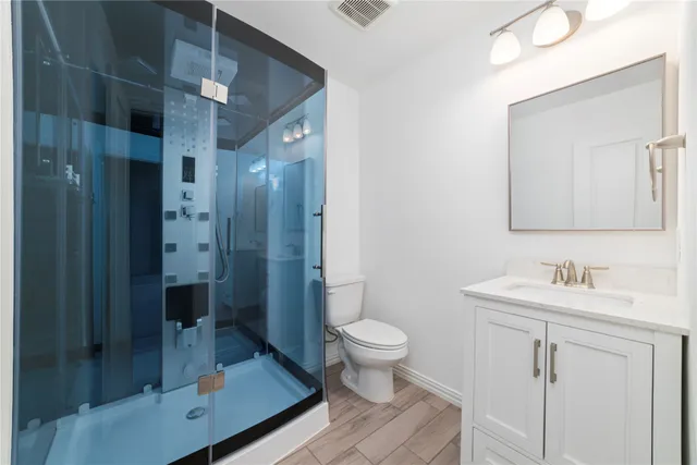 a bathroom with a sink a toilet and shower