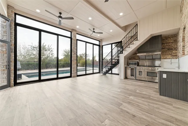 a view of an empty room with wooden floor and stairs