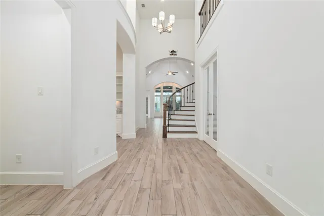 a view of a hallway with wooden floor and staircase