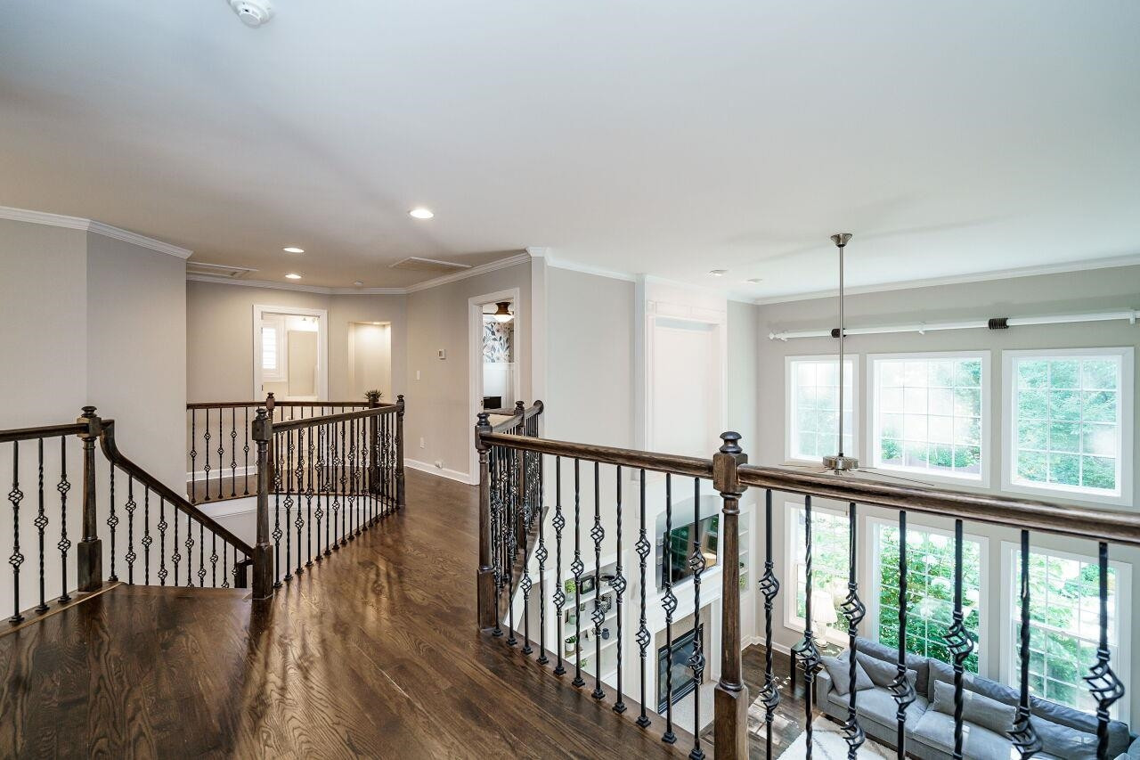 3003 Red Grape Drive Raleigh, NC 27607 - Photo 24 of 35 Pristine hardwoods and wrought iron rails line this upstairs catwalk to additional bedrooms and bonus room! Upstairs Hallway