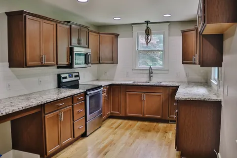a kitchen with stainless steel appliances granite countertop wooden cabinets and a granite counter tops