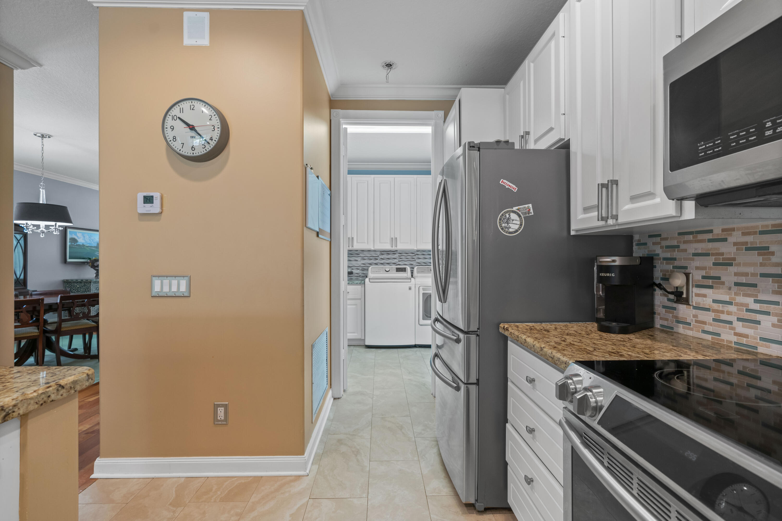 144 Sweet Bay Circle Jupiter, FL 33458 - Photo 24 of 46 a kitchen with a refrigerator and a stove top oven