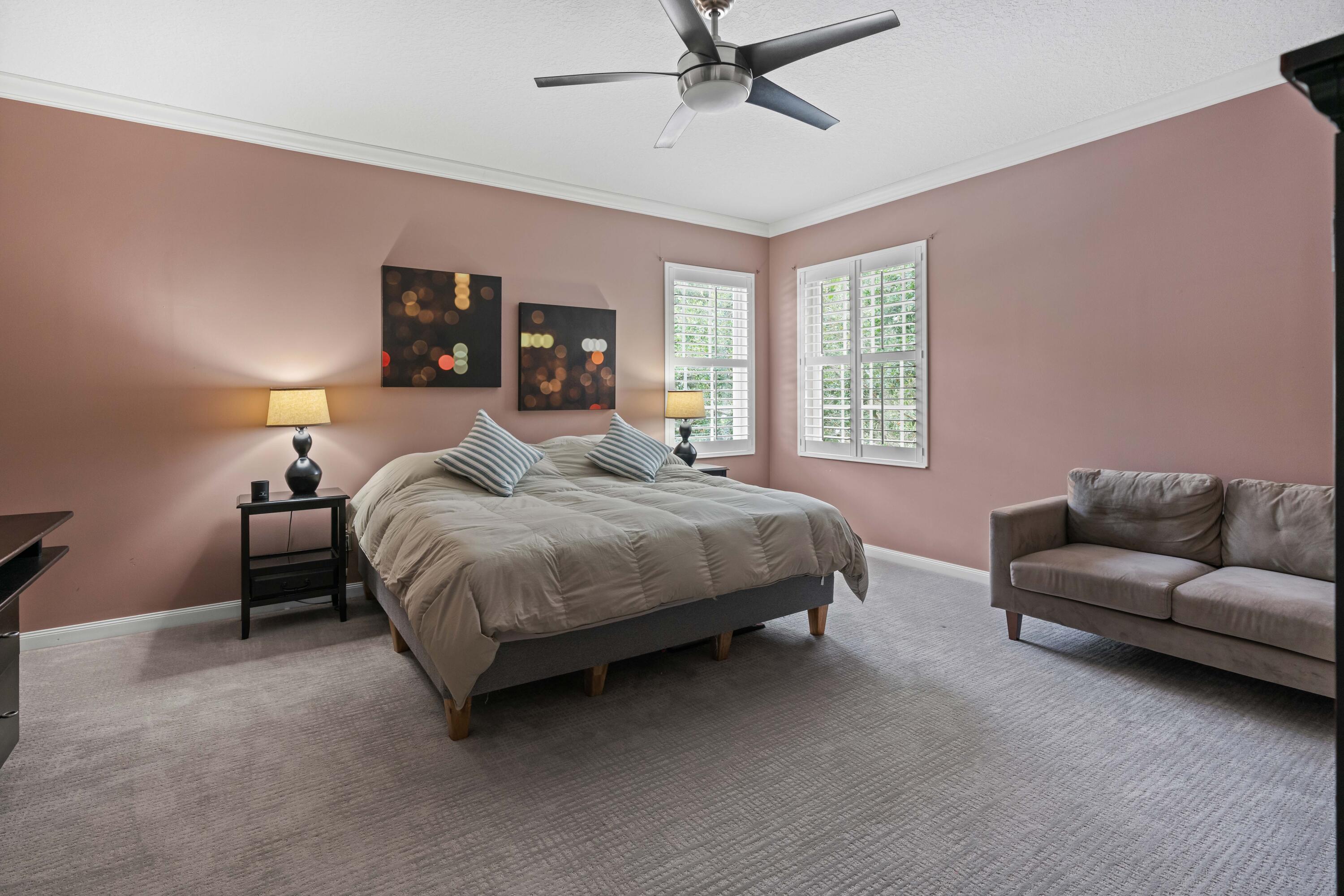 144 Sweet Bay Circle Jupiter, FL 33458 - Photo 28 of 46 a bedroom with a bed couch and a window