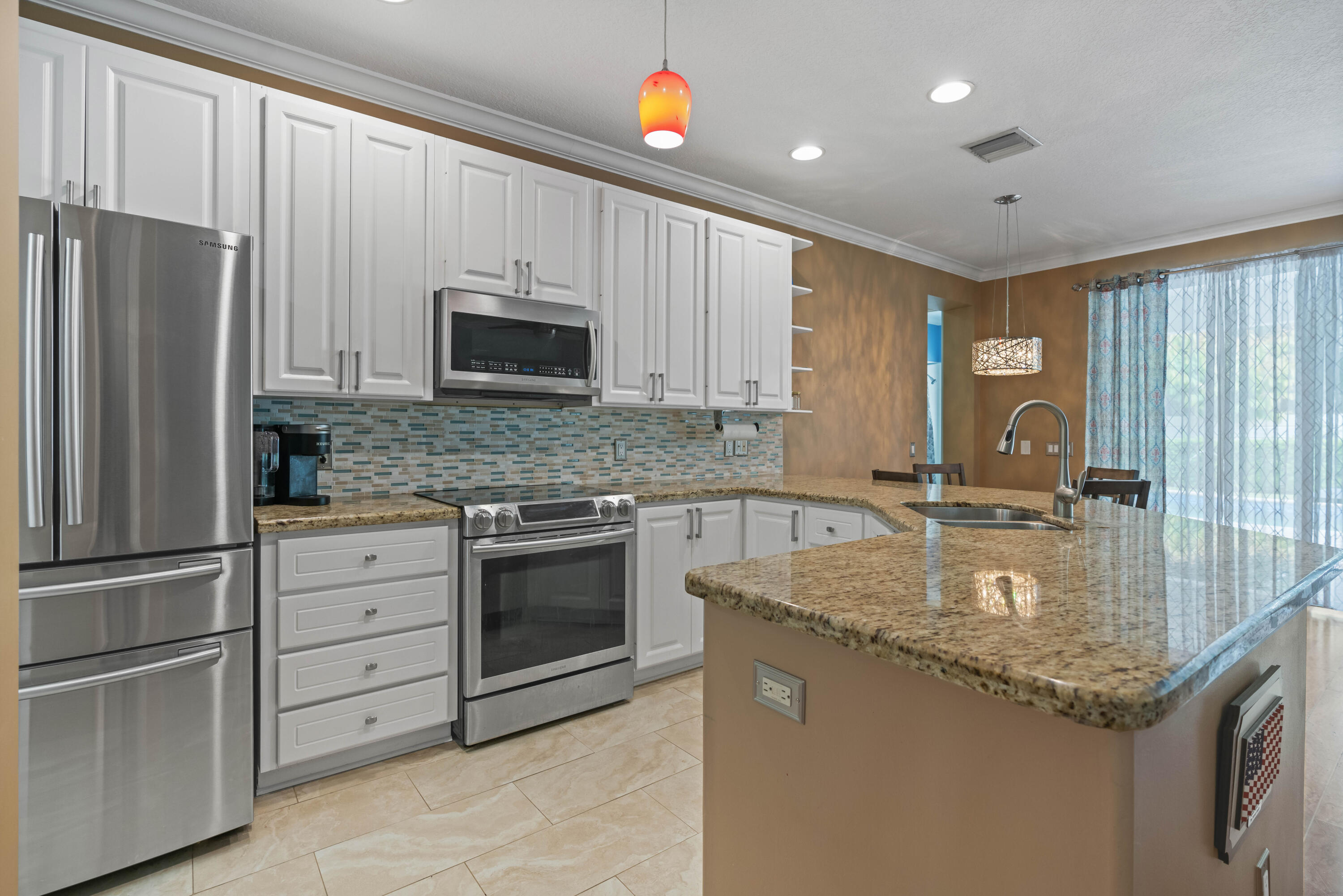 144 Sweet Bay Circle Jupiter, FL 33458 - Photo 7 of 46 a kitchen with granite countertop stainless steel appliances a stove sink and microwave